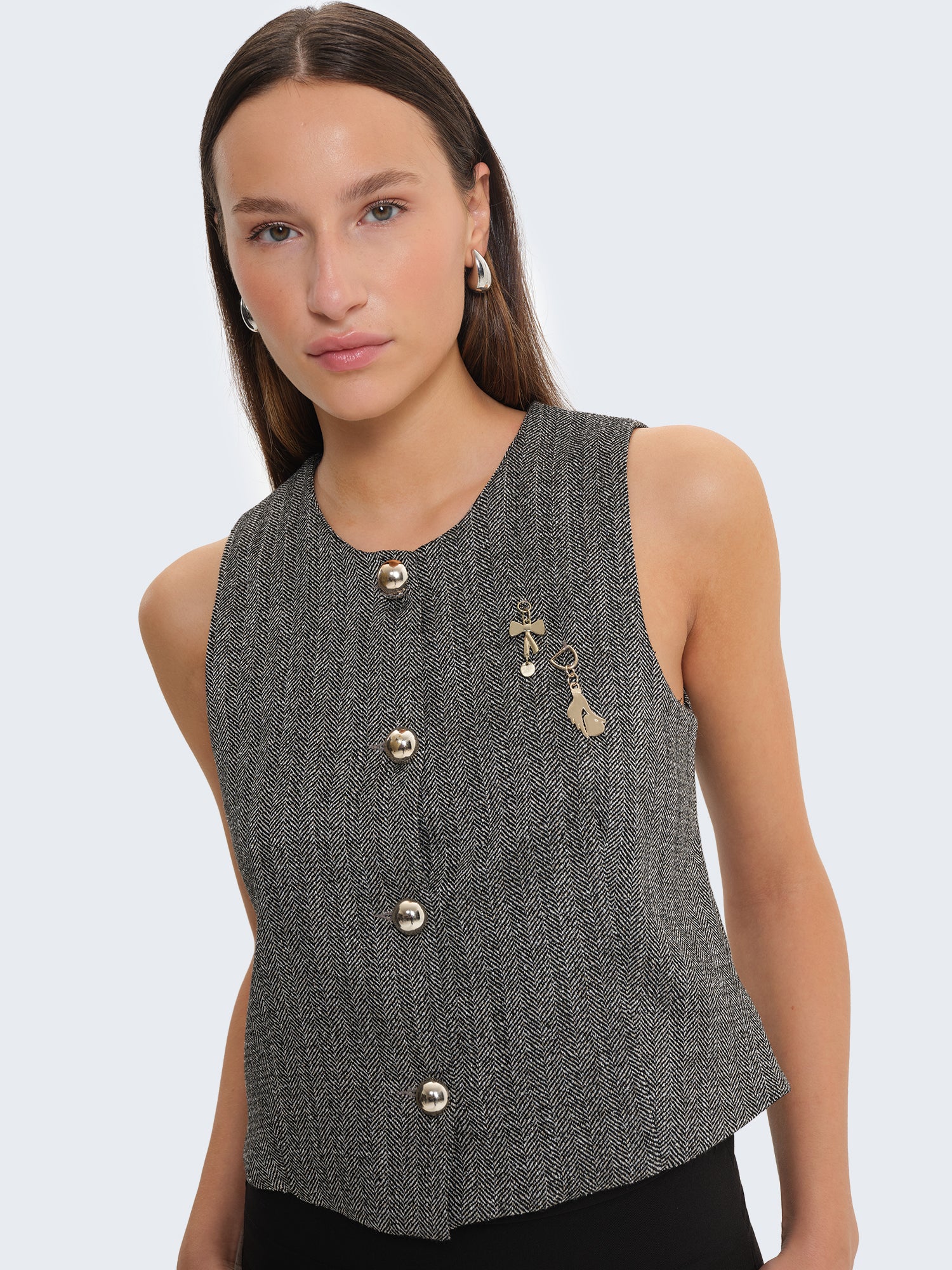 Gilet con tessuto spigato e charms